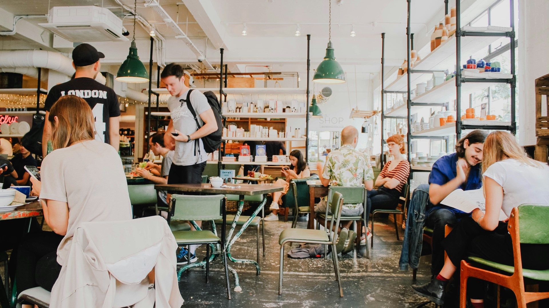 Café ähnlicher Raum in dem Menschen sitzen, arbeiten und sich unterhalten