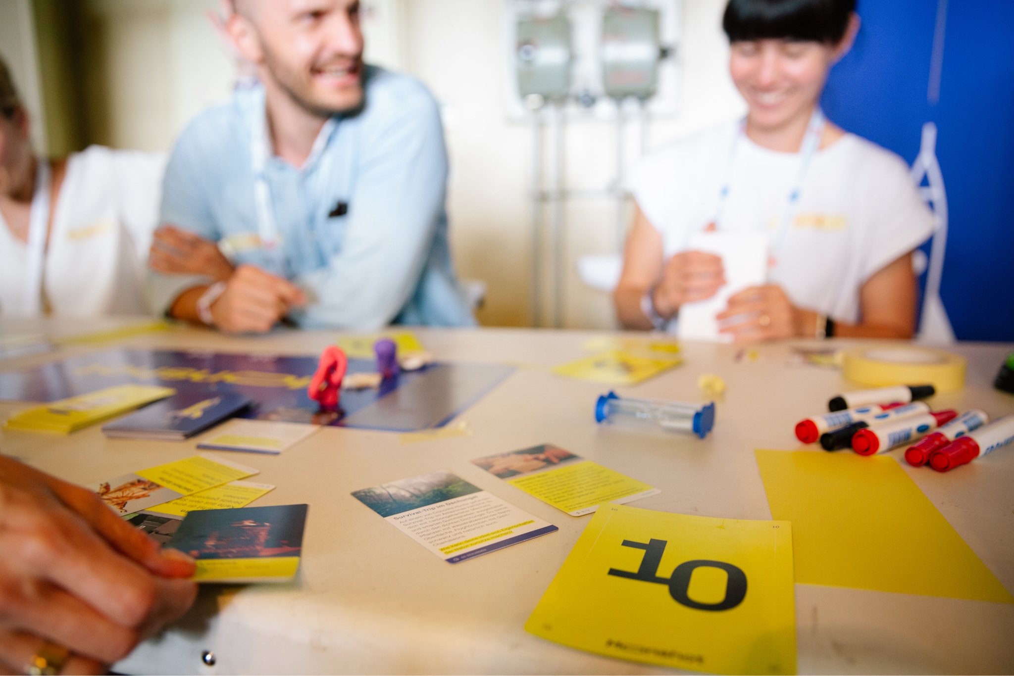 Menschen am Tisch mit Spielkarten von Moonshot